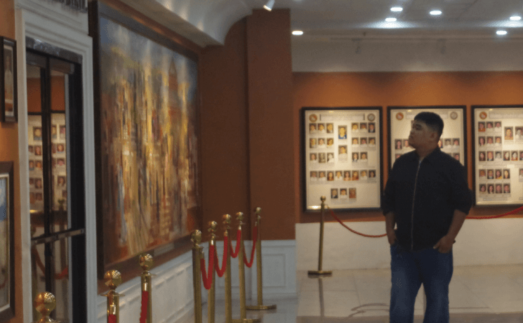 John Rey Silverio viewing artwork in a gallery